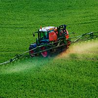 Tractor spraying crop protection chemicals on a field